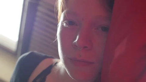 Young girl in bed looking in camera Видео 73541011