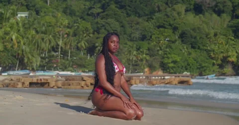 A young girl in a bikini posing with one hand on her hip on a golden beach. Stock Footage 330961925