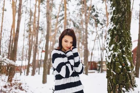 Young girl in black and white sweater in the cold at the forest under the pin Stock Photos