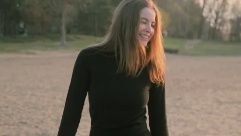 Young girl in black clothes smiling, at riverside Stock Footage