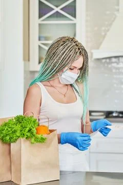 A young girl with blue dreadlocks looks at a cash receipt Stock Photos