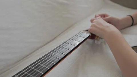 Young girl changing strings on a classical guitar. Stock Footage 233505231