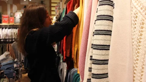 Young girl is choosing clothes at the store Video stock 123722128