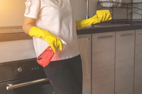 Young girl cleaning in the kitchen, concept photo of cleaning service worker Foto stock