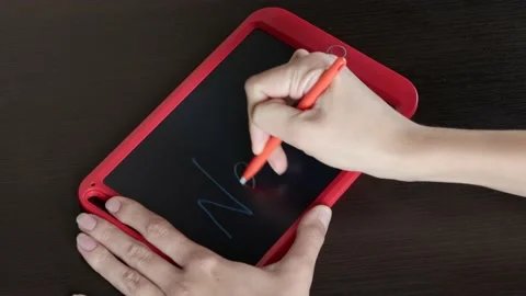 A young girl close-up writes a word on a tablet - Next Stock Footage 145125853