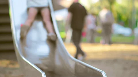Young girl comes down a slide and smiles Stock Footage 51746931