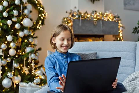 A young girl communicates remotely using a computer. New year greetings via t Stock Photos