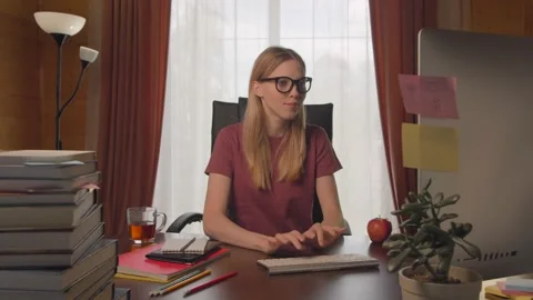 Young girl at computer table, typing on keyboard, calls on video link, happy Video stock 132890654