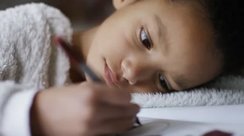 Young girl concentrating on her colouring in book Stock Footage 59556468
