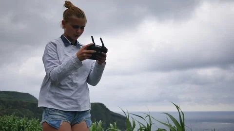 Young girl controls a drone in windy weather against the backdrop of a powerful Stock Footage 101942553