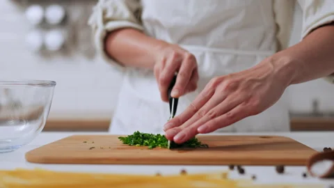 Young girl cook trainee cuts vegetables for cooking. A white girl is standin Stock Footage 242539368