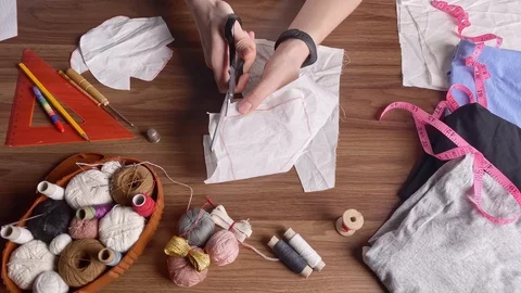 Young girl cuts out patterns with scissors for sewing a reusable protective m Video stock 128363071