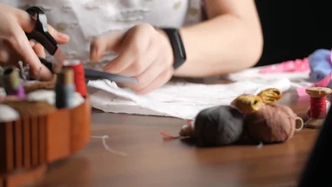 Young girl cuts out patterns with scissors for sewing a reusable protective m Stock Footage 128363436