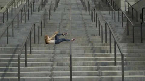 Young girl dancer dancing lying on the marble steps. straight lines video. 4K Stock Footage 136470300