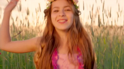 Young girl dancing under confetti rain in the wheat field during sunset Stock Footage 64776818