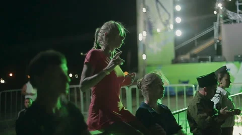 Young Girl Dancing While Sitting on the Parapet at Night Stock Footage 60681543