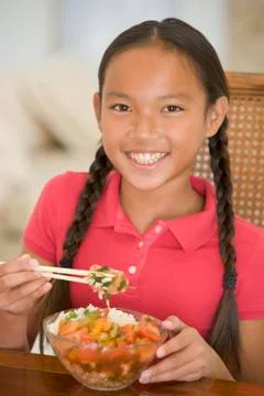 Young girl in dining room eating chinese food smiling Stock Photos