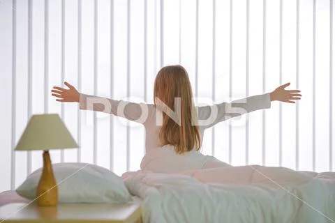 The young girl do exercise near the bed Stock Photos