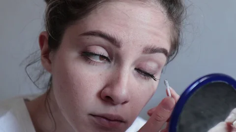 Young girl do makeup looking in mirror close up Video stock 127744300