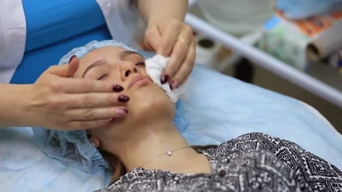 The young girl does cleaning of face skin at the beautician. Cleaning face skin Stock Footage 136511987