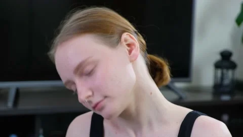 A young girl does an exercise on her neck. Stock Footage 200788975