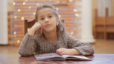 A young girl does homework, leafs through pages of a book. Stock Footage 120268423