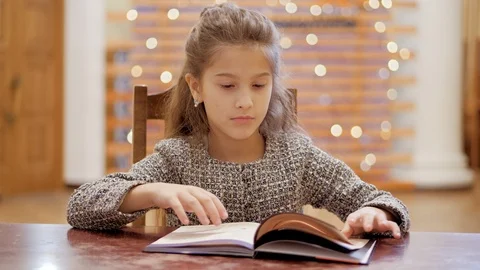 A young girl does homework, leafs through pages of a book. Stock Footage 120268467