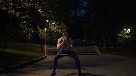 Young girl doing exercise in the evening park Stock Footage 119116432