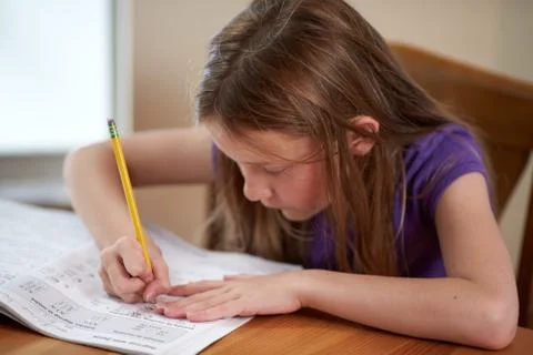 Young girl doing math homework at a table Foto stock