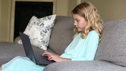 Young girl doing school work from home on a laptop computer Vídeos de archivo 137337491