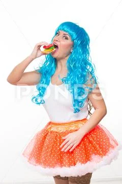 Young girl doll with blue hair. plastic eating a sandwich. hunger Stock Photos