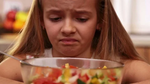 Young girl dreading every icky bite of vegetables salad Stock Footage 80104386