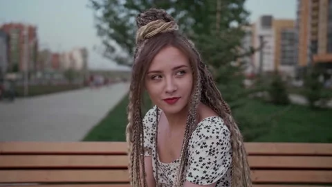 Young girl with dreadlocks posing on a bench Stock Footage 154722479
