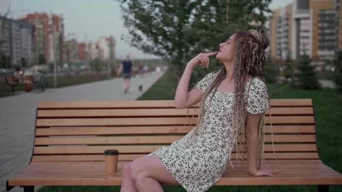Young girl with dreadlocks posing on a bench Stock Footage 154722753