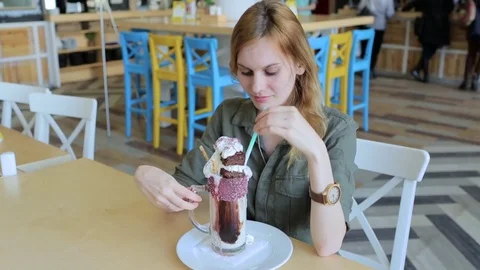 Young girl is drinking cocktail in cafe Stock Footage