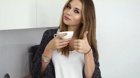 Young girl drinking coffe in the kitchen. Indoor photo. Positive emotions Video stock 56691245