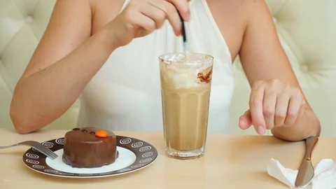 A young girl drinks a cocktail at a cafe and eats a chocolate dessert. 4k slow Stock Footage