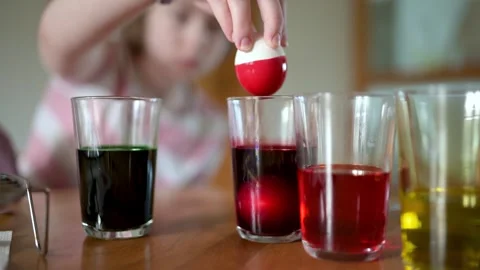 Young girl dyeing Easter eggs at home. Slow motion close-up footage. 库存影片 301933317
