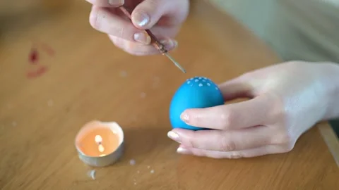 Young girl dyeing Easter eggs at home. Slow motion close-up footage. Stockbeeldmateriaal 304087150