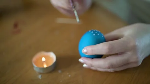 Young girl dyeing Easter eggs at home. Slow motion close-up footage. Stockbeeldmateriaal 305775564