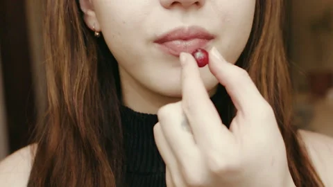 A young girl eats a berry. Face close up. HD Stockbeeldmateriaal 101660091