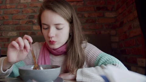 Young girl eats borscht in a cafe Stock Footage 194031495