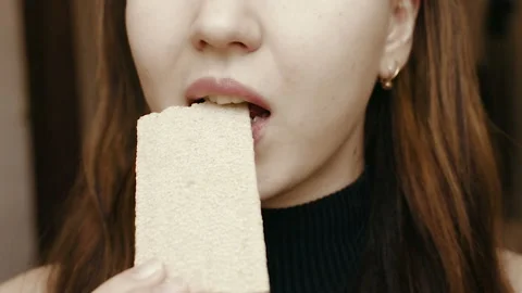 A young girl eats bread. Close-up face. Healthy food. HD Video stock 101660036