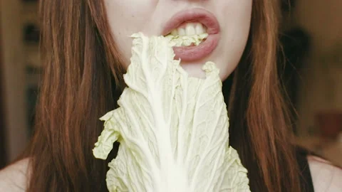 A young girl eats cabbage. Close-up face. HD Видео 101660513