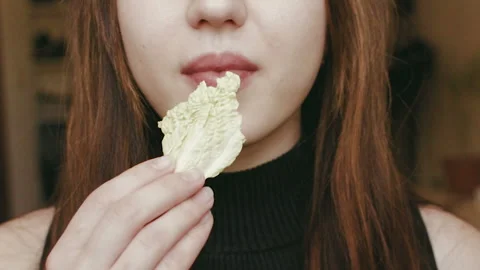 A young girl eats cabbage. Close-up face. HD Stock-Footage 101660524