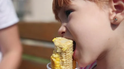 A young girl eats corn off of the cob Stock Footage 66461851