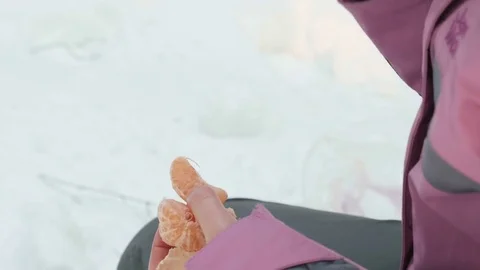 Young girl eats mandarin in the winter forest Stock Footage 73895205
