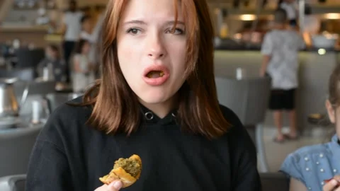 Young girl eats something in hotel restaurant 스톡 동영상 196266297