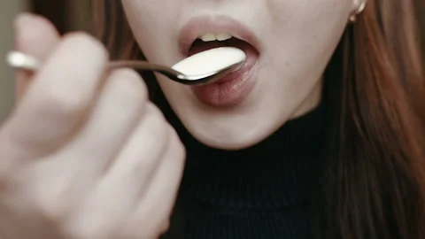 Young girl eats yogurt. Light breakfast. Close-up face. HD Видео 101660651
