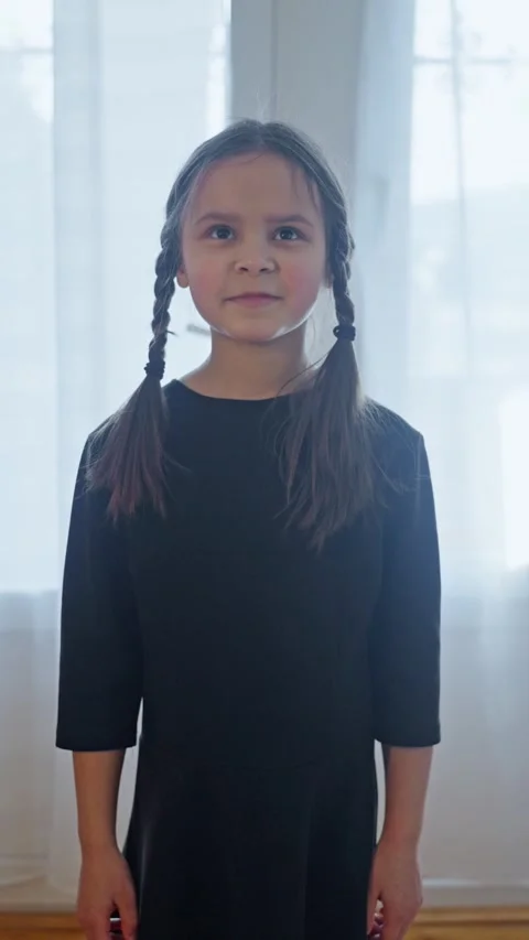 Young girl, elegantly dressed in dark clothing with beautiful braids, evokes a Stock Footage 303672341
